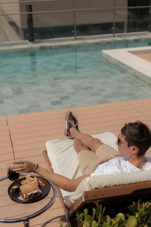 a man laying in a chair next to a table with a cake at Hub Hotel Asuncion in Asuncion