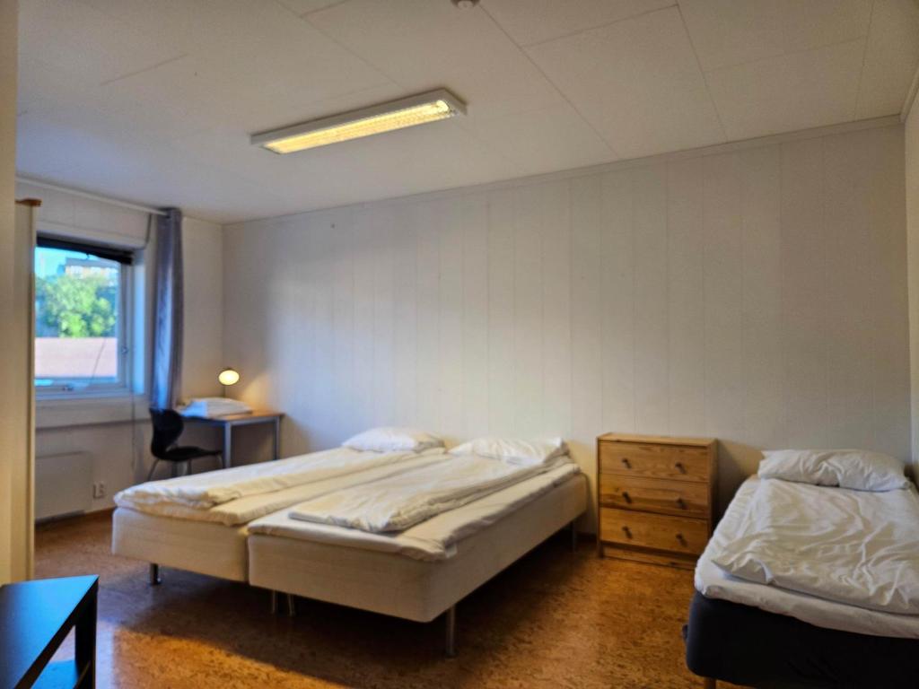 Un dormitorio con dos camas y una mesa y una ventana. en Twin room 207 near Kristiansand, en Vennesla