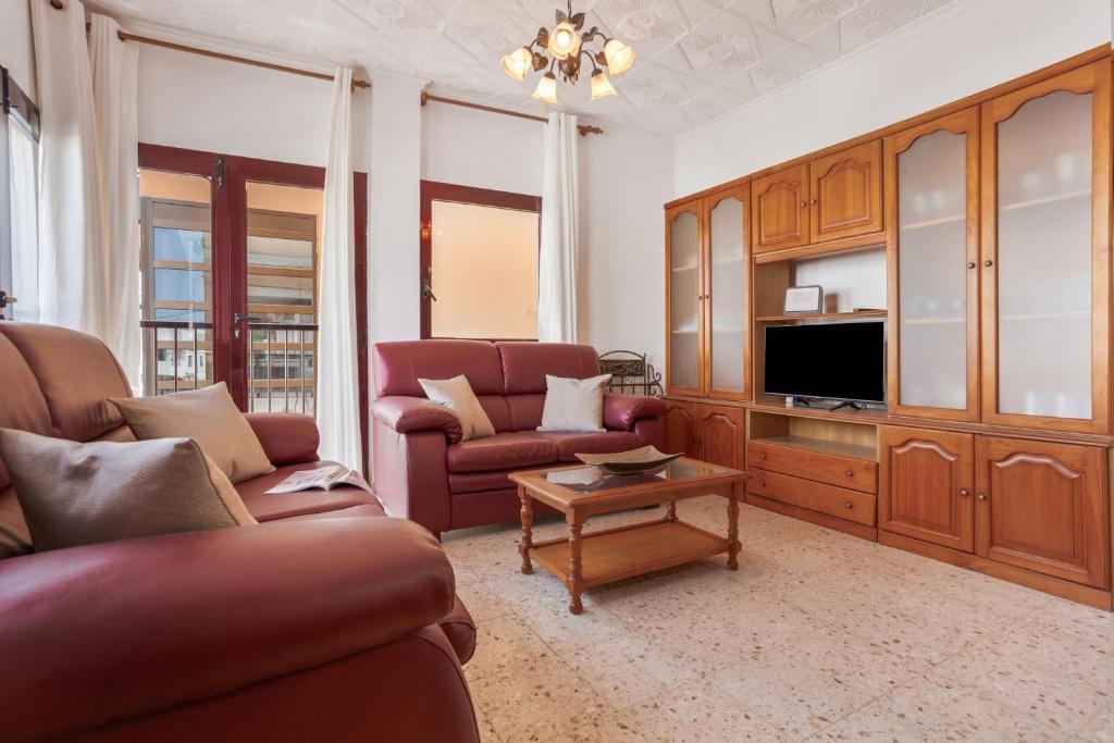 a living room with a couch and a tv at Casa Abuela Maruca in Corralejo