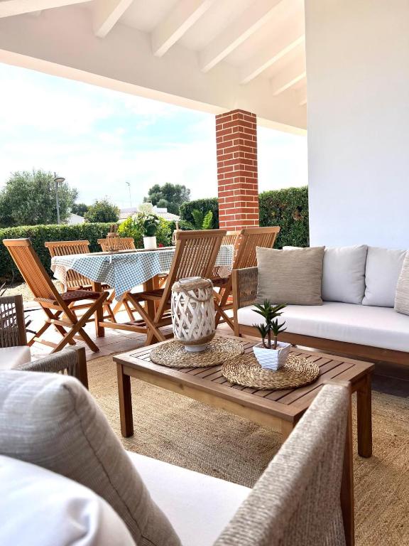 a patio with a couch and a table and chairs at Villa Aire in Cala en Blanes