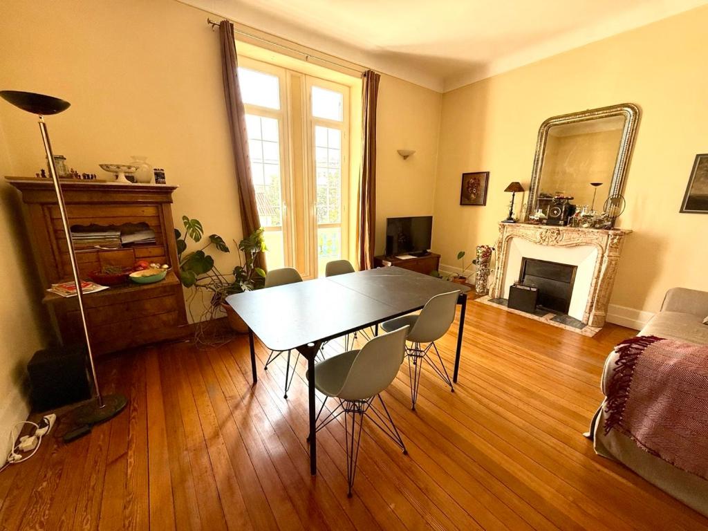 un salon avec une table et des chaises et une cheminée dans l'établissement Les Arènes de Cimiez, à Nice