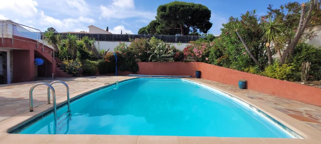 une grande piscine bleue dans une cour dans l'établissement Villa Palm' Issambres 6-7 personnes, clim, avec piscine, jardin et parking privés, à La Garonnette-Plage