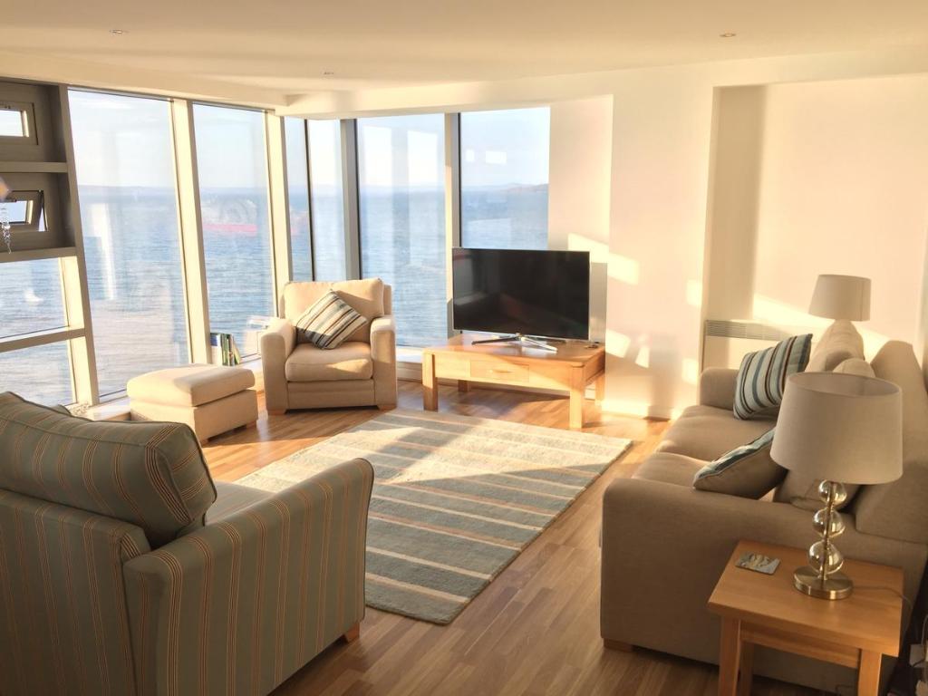 a living room with two couches and a television at Edinburgh Western Harbour in Edinburgh