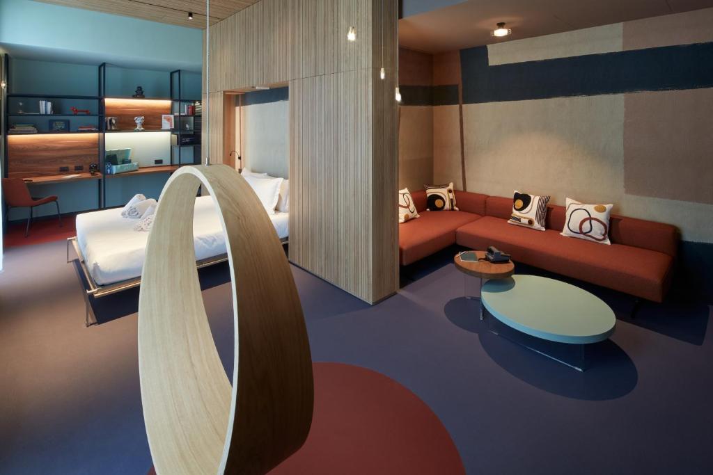 una camera d'albergo con un letto e un divano di 21 House of Stories Navigli a Milano