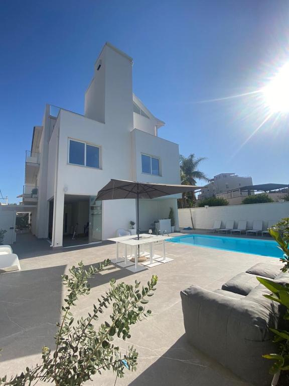 a large white building with a pool and an umbrella at Just Light in San Leone