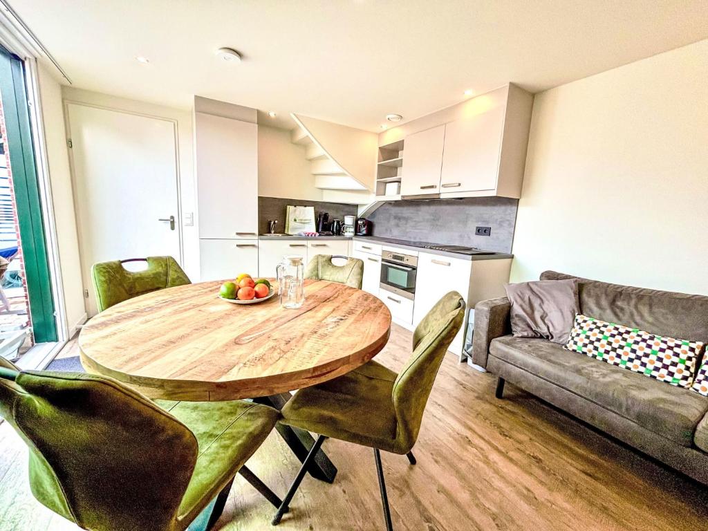 Una cocina y un comedor con mesa y sillas de madera. en Holiday Home Beach House Westkapelle 103 C by Interhome, en Westkapelle
