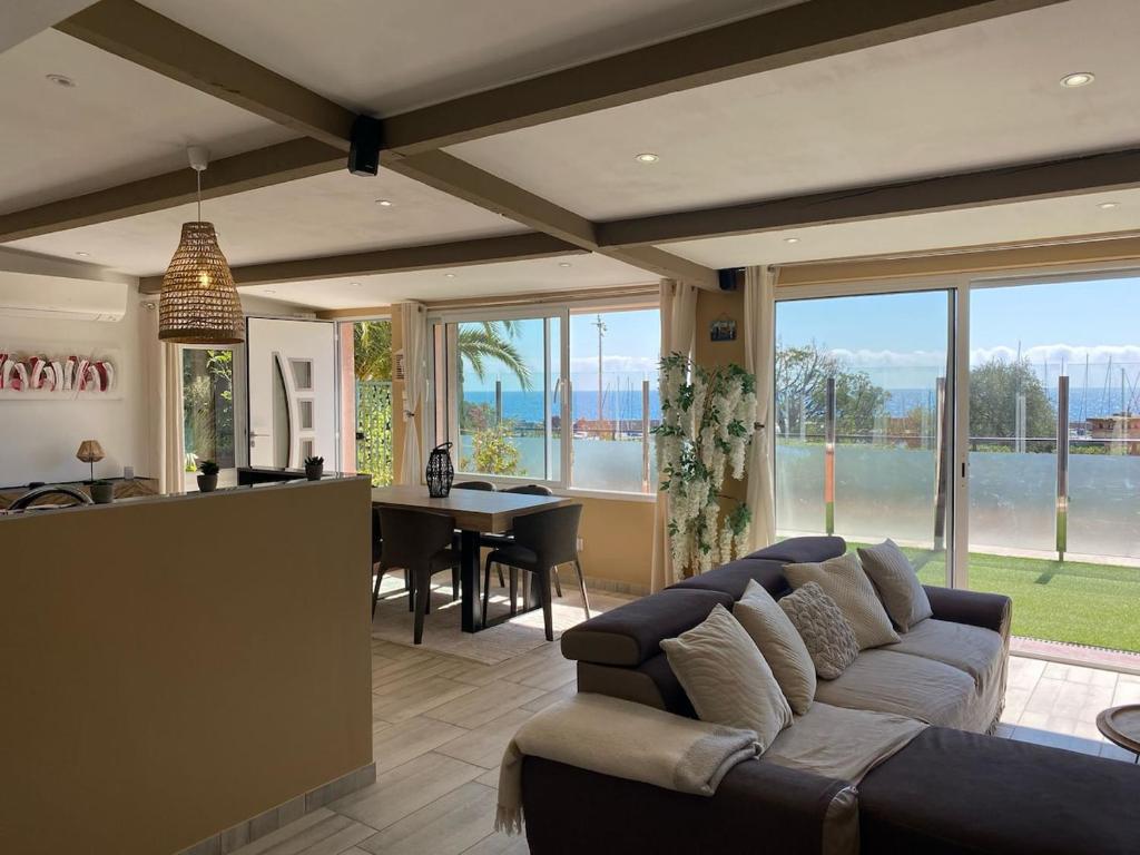 un salon avec un canapé et une salle à manger dans l'établissement Fabuleux 3 pièces face à la plage, à Théoule-sur-Mer