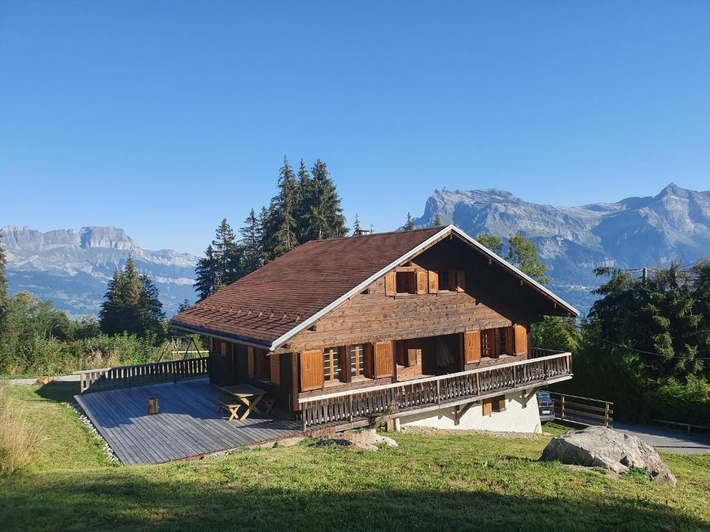 une maison construite avec des montagnes en arrière-plan dans l'établissement Les Valamonts, à Saint-Gervais-les-Bains