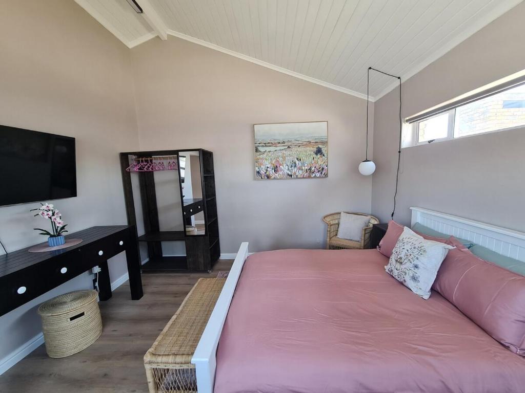 a living room with a pink couch and a tv at LieBling Place in Cape Town