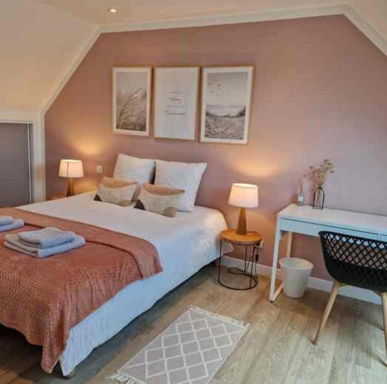 une chambre avec un grand lit et une table dans l'établissement Maison familiale en centre ville de Châteaulin, à Châteaulin