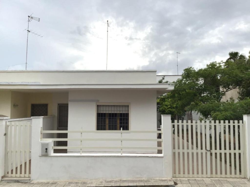 a white fence in front of a white house at Villa Antonietta in Torre Lapillo