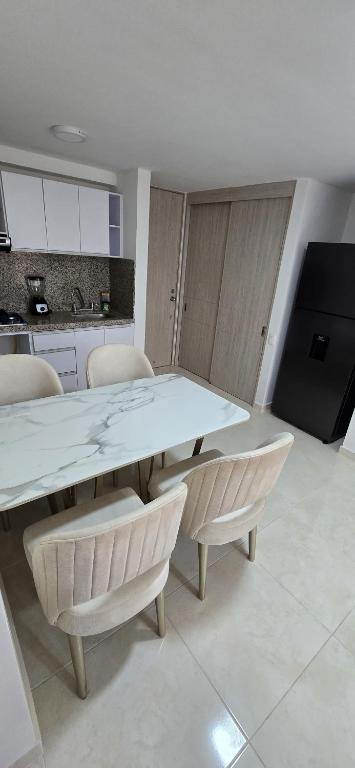 a kitchen with a large white table and chairs at Apartamento Plazuela Portal Del Prado in Barranquilla