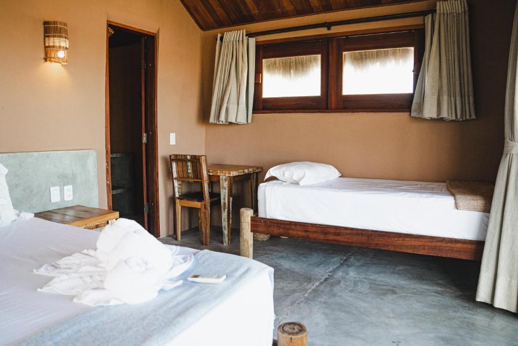 a room with two beds and a window at Tatadise in Tatajuba