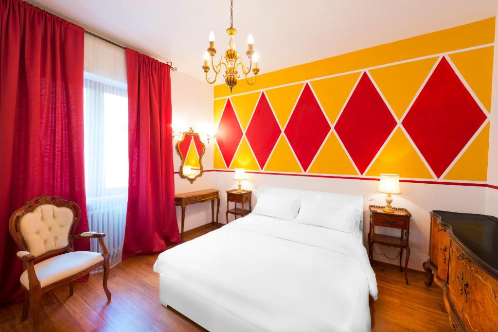 ヴェローナにあるVerona Centre Apartmentsの白いベッドと赤と黄色の壁が備わるベッドルーム1室が備わります。
