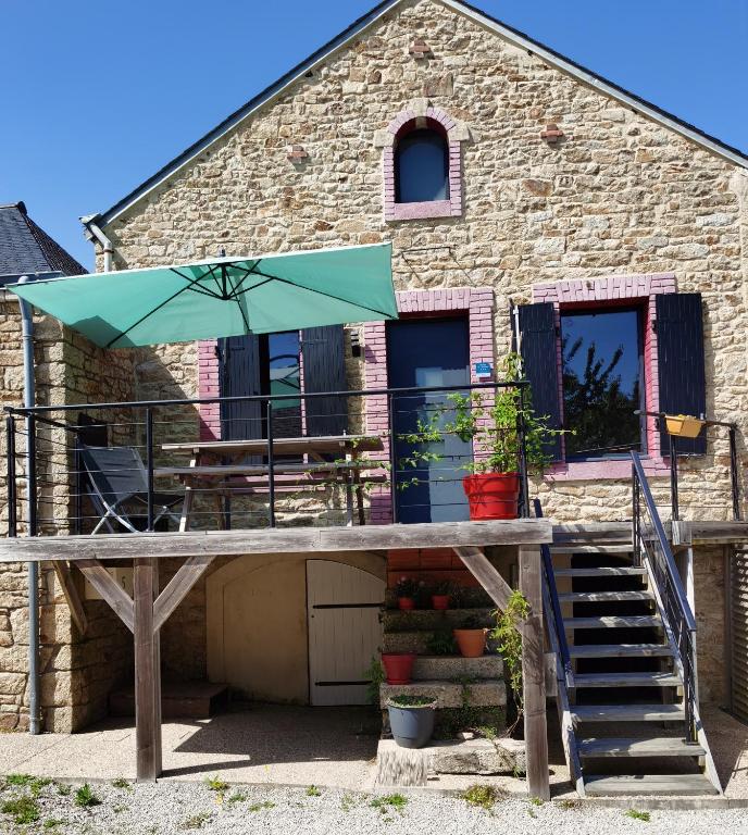 un patio avec une table et un parasol dans l'établissement La maison Kerserho, à Plouhinec