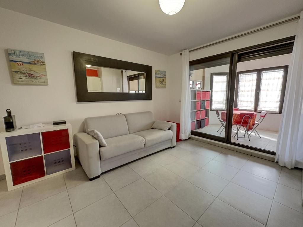 un salon avec un canapé et un miroir dans l'établissement Centre Juan les Pins studio avec loggia Standing Rives Bleues, à Antibes