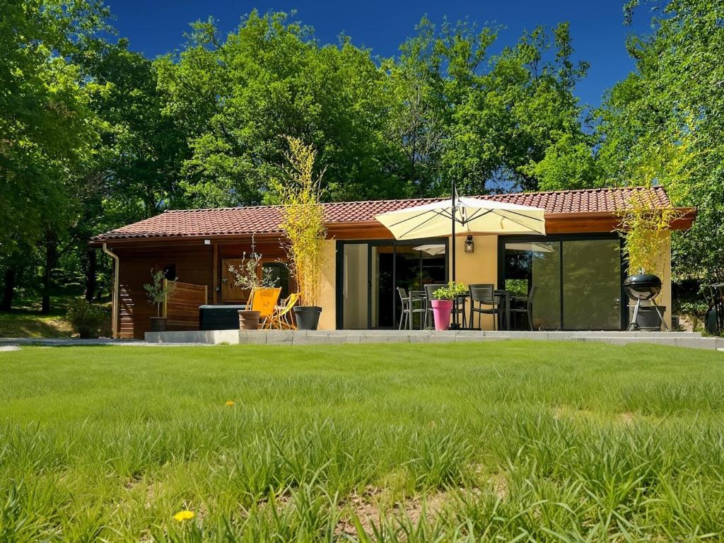une petite maison avec une pelouse devant elle dans l'établissement Charming country house between Lot and Dordogne, à Monsempron-Libos
