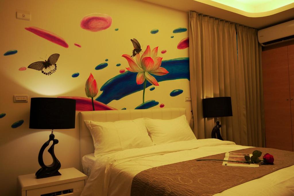 a bedroom with a bed and butterflies on the wall at Grand Allevia Villa in Wujie