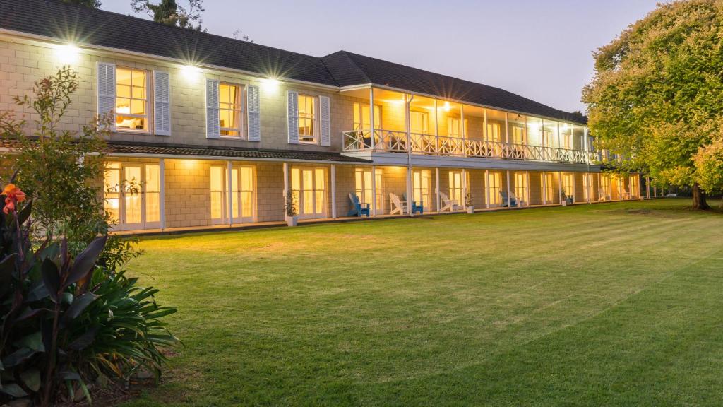 a large building with a lawn in front of it at Discovery Settlers Hotel in Whangarei