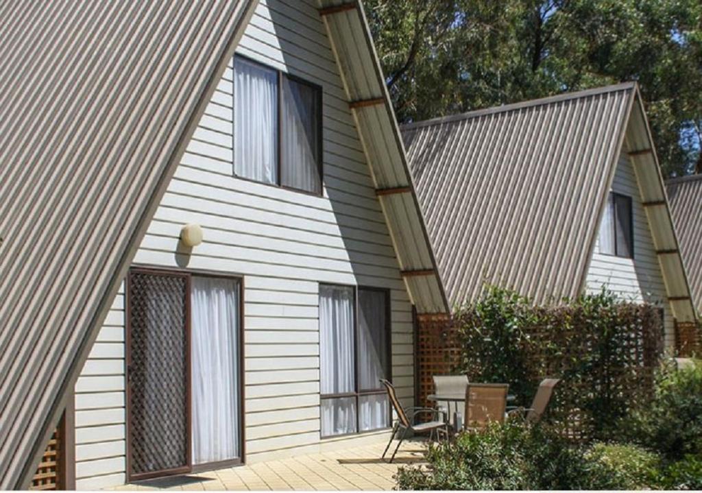 a house with a table and chairs in front of it at A-Line Holiday Park in Bendigo