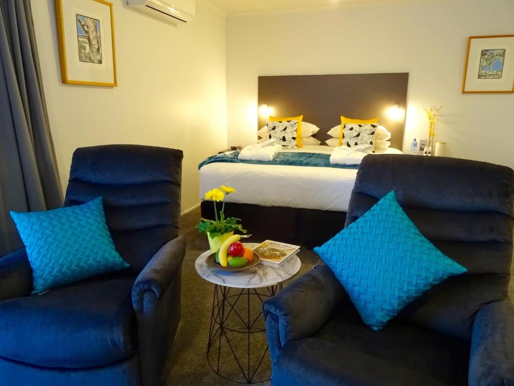 Habitación de hotel con 2 sillas y 1 cama en BKs Premier Motel Hamilton, en Hamilton
