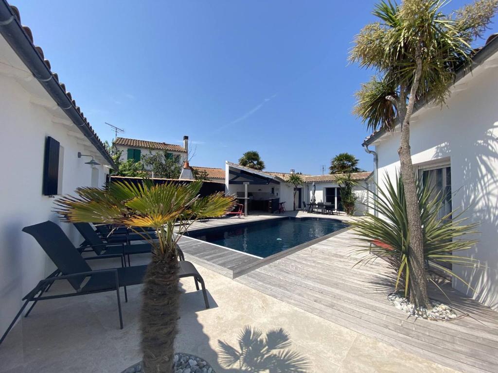 a villa with a swimming pool and palm trees at La Villa des Vignes in Les Caillaux