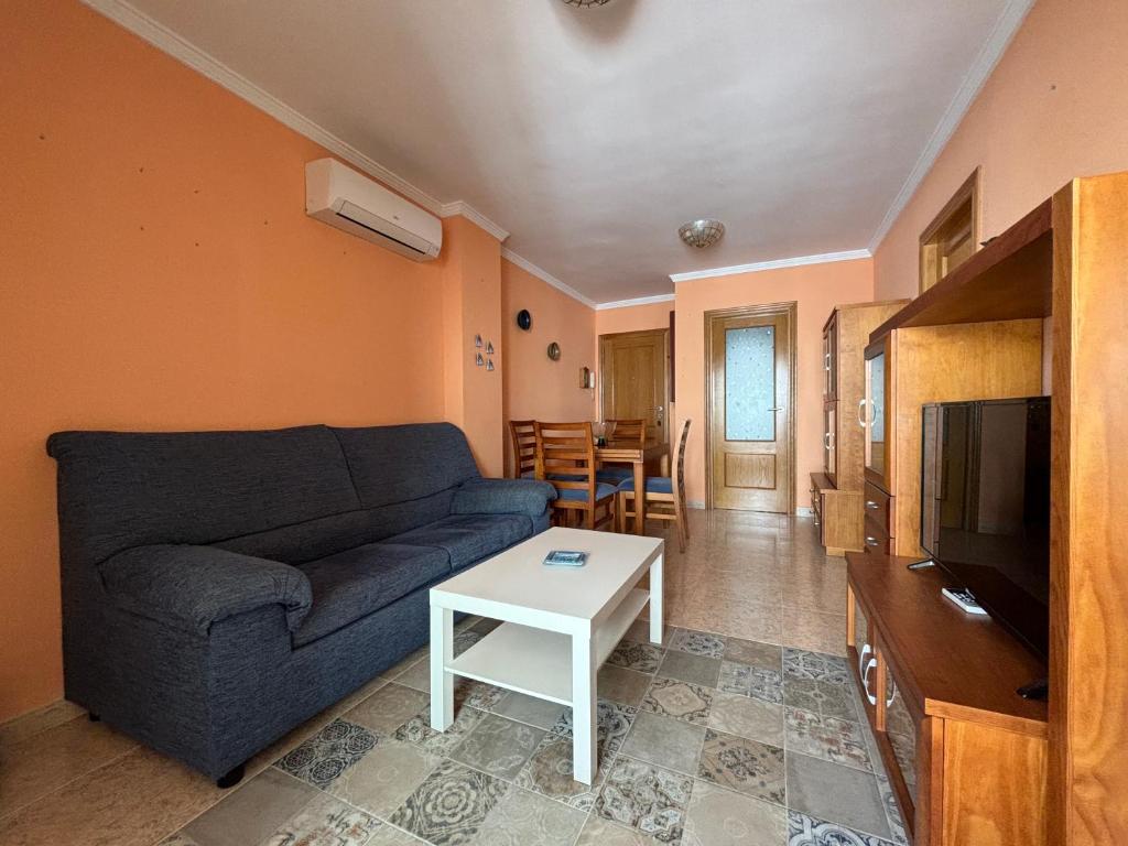 a living room with a blue couch and a table at Voramar VI in Piles