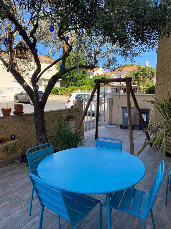 une table et des chaises bleues sur une terrasse dans l'établissement Favola di Carla, à Mèze