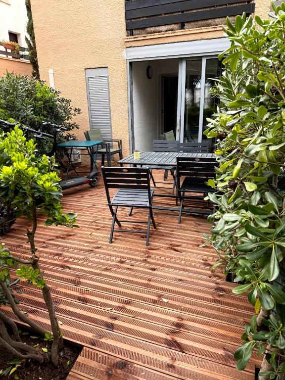 une terrasse en bois avec des bancs et des tables sur une maison dans l'établissement Le Cap'rice, au Cap d'Agde