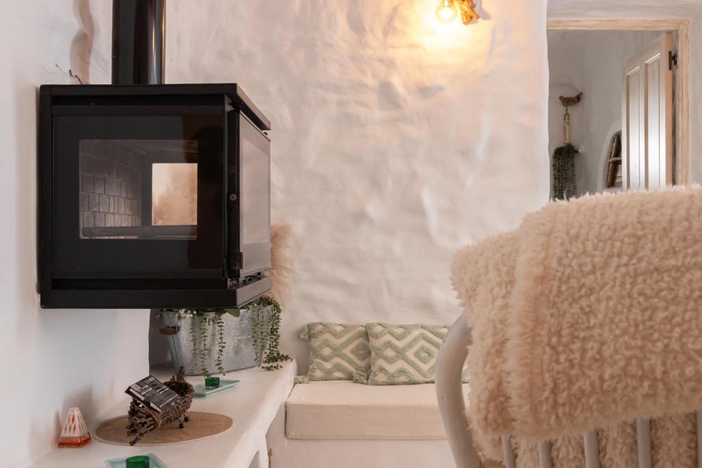 a television hanging on a wall in a living room at Complejo Cuevas Otto in Baza