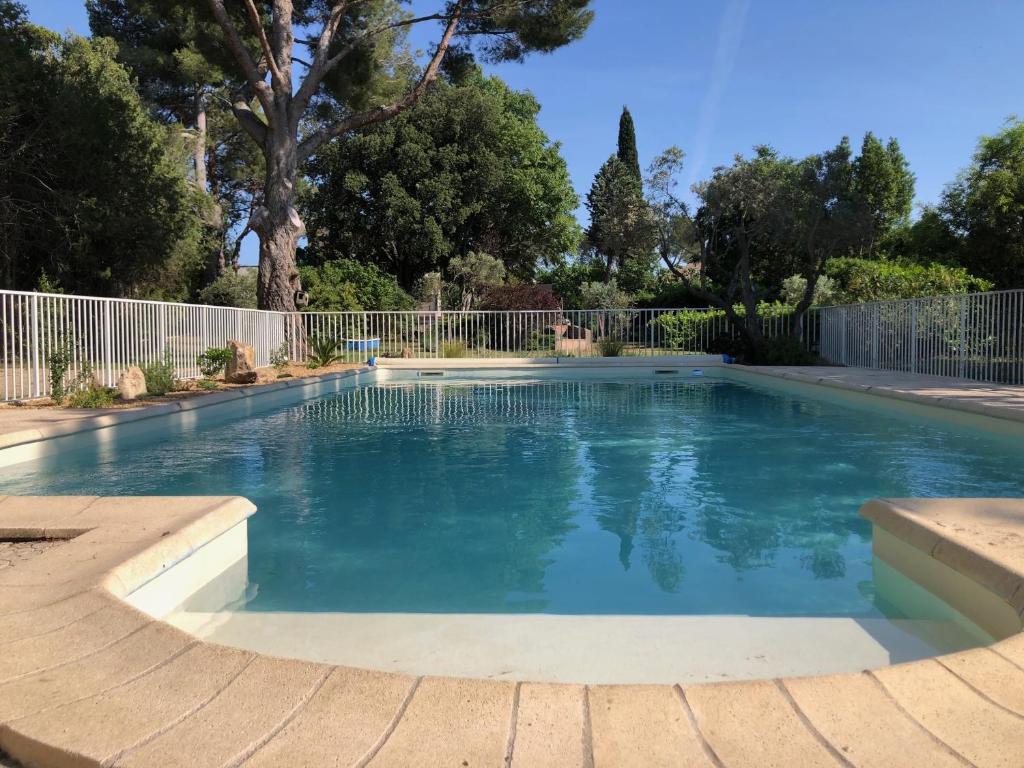 une piscine avec de l'eau bleue dans une cour dans l'établissement Gite 5 à 7 personnes en Provence dans grand jardin avec piscine partagée, à Cornillon-Confoux