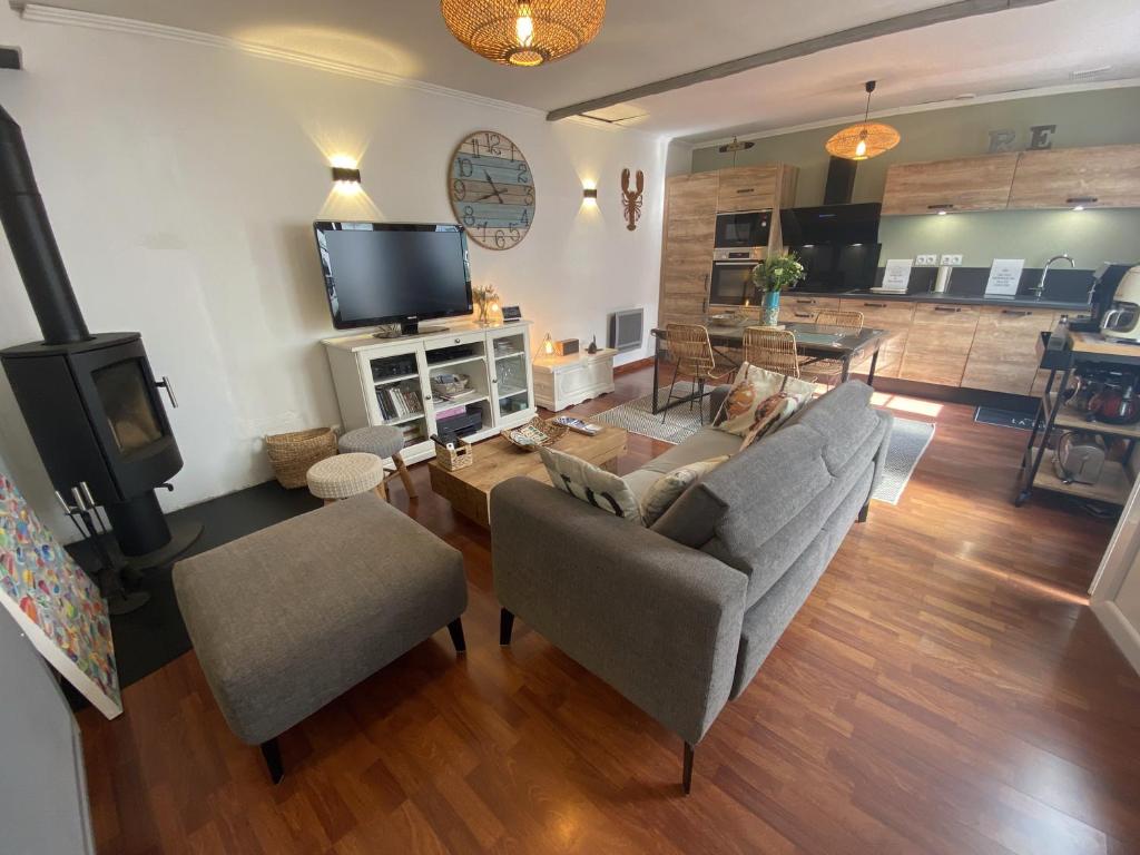 a living room with a couch and a tv at La maison de la Sauzaie in La Flotte