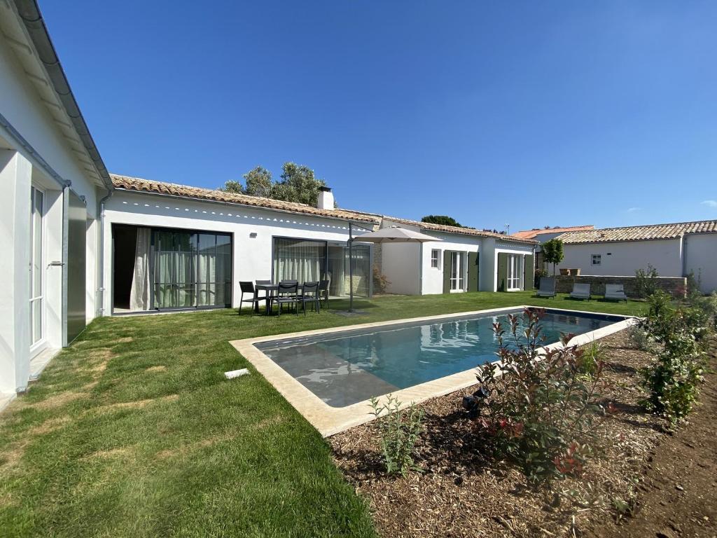 une cour arrière avec une piscine et une maison dans l'établissement La Villa Mirabelle, à Loix