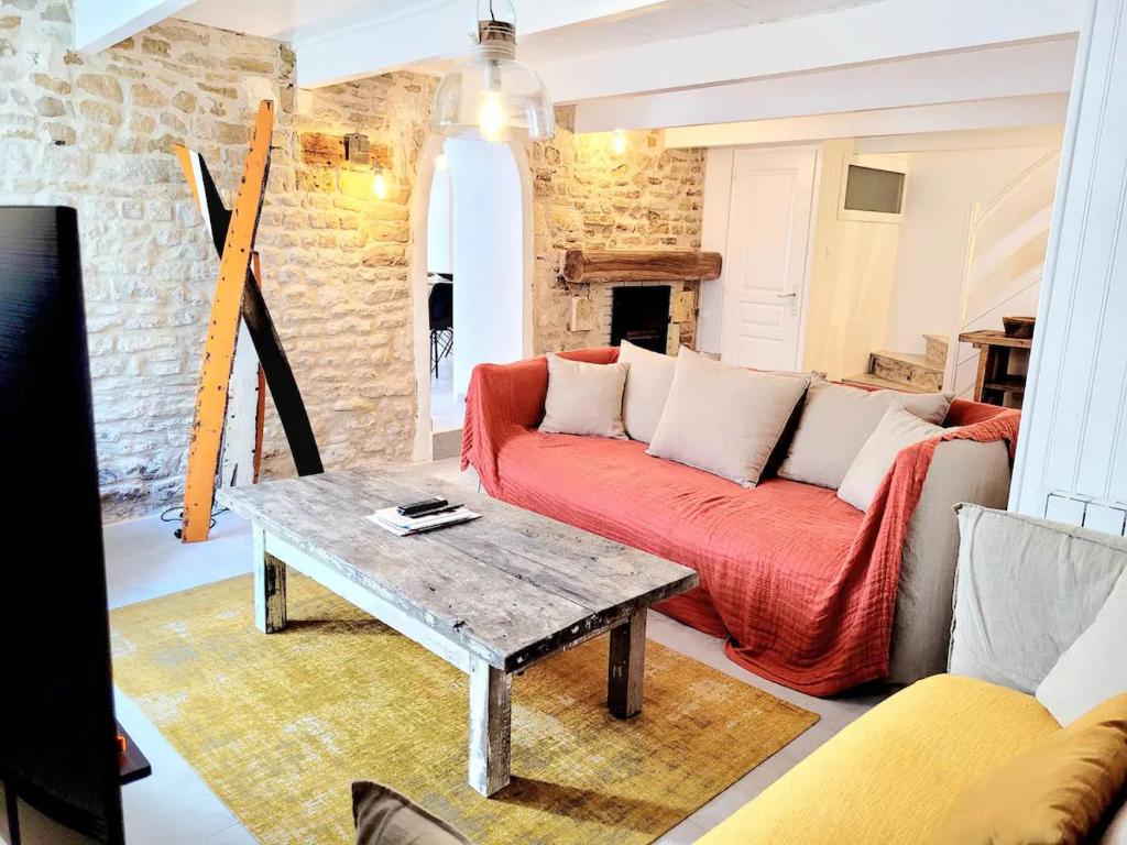 a living room with a couch and a table at La Maison du Puits Fleuri in Ars-en-Ré