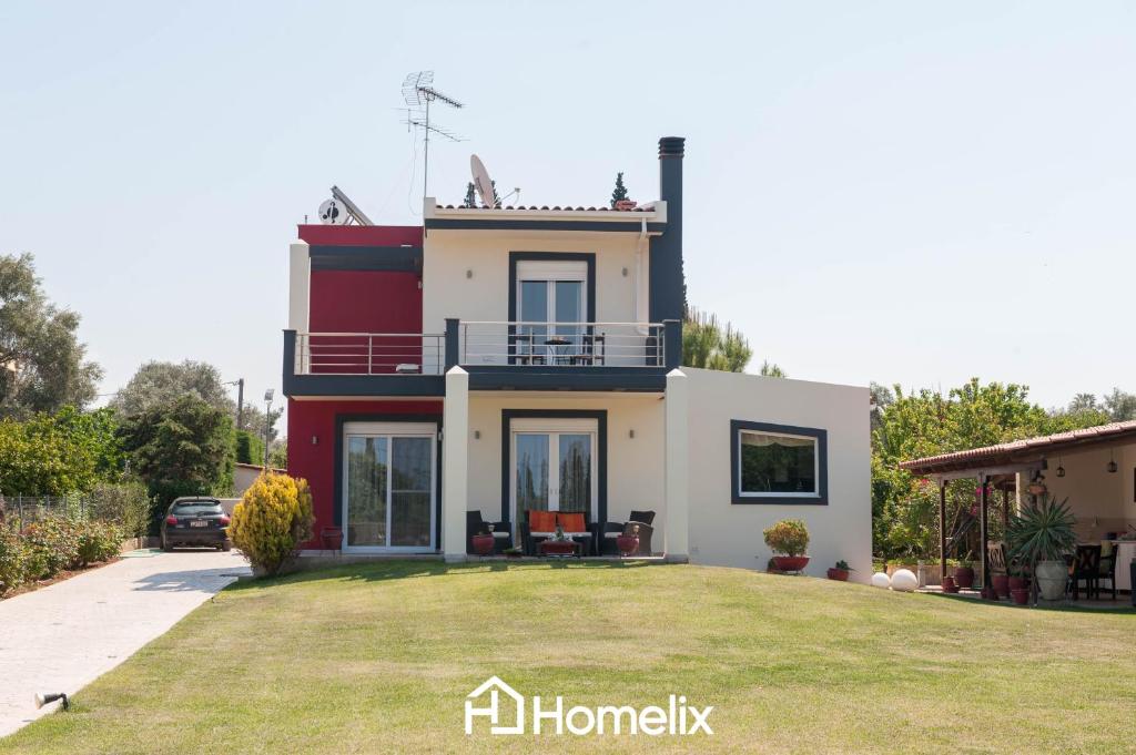 a house with a large yard in front of it at Villa Roses in Drosia