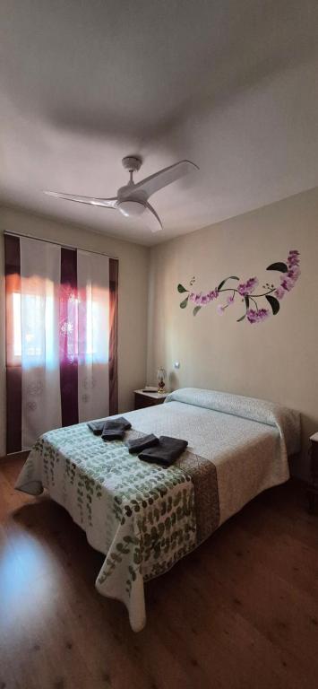 a bedroom with a bed with flowers on the wall at Chalet vacacional en Pelayos in Pelayos de la Presa