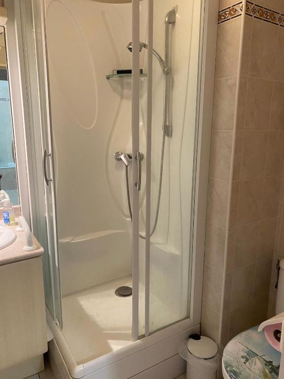 une douche avec une porte vitrée dans une salle de bain dans l'établissement Confort au calme, à Saint-Aygulf