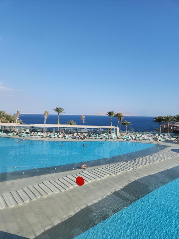 a large swimming pool with a red ball in the water at Cosy Romantic Sea View Villa at a 5 Hotel in Sharm El Sheikh