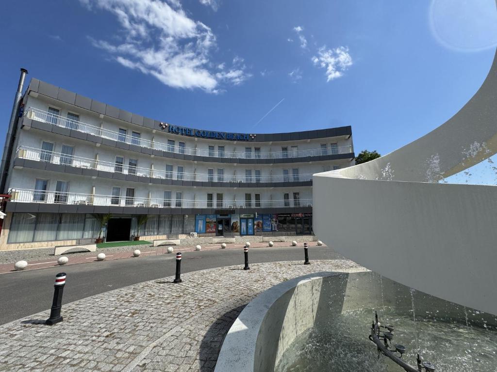 a building in front of a street with a building at Hotel Golden Beach in Eforie Nord