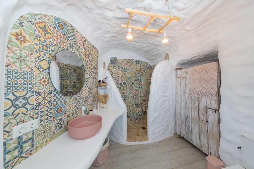 a bathroom with a toilet and a sink in a room at Complejo Cuevas Otto in Baza