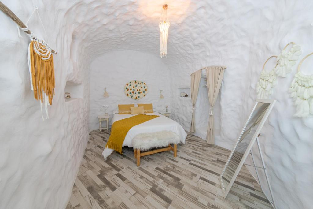 a bedroom with a bed in a white room at Complejo Cuevas Otto in Baza