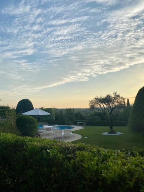 - une vue sur un parc avec une table et un parasol dans l'établissement Villa familiale dans beau domaine, à Villeneuve-Loubet