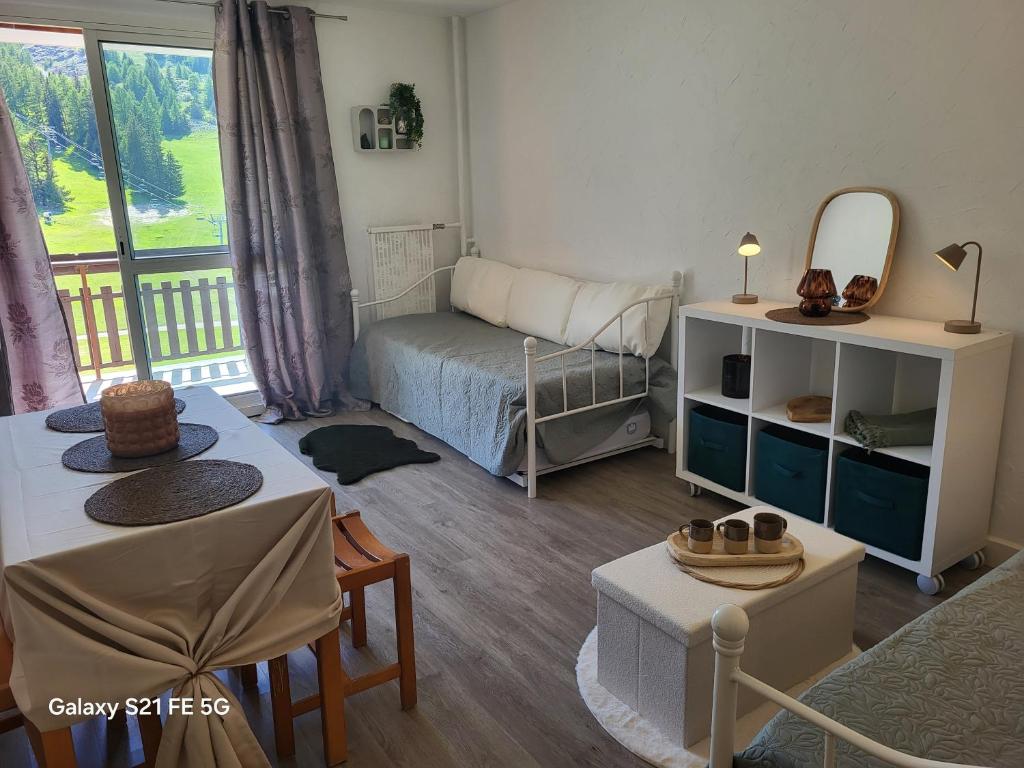 - un petit salon avec un lit et un miroir dans l'établissement VACANCES à SUPERDEVOLUY hautes Alpes 05250, à Superdevoluy