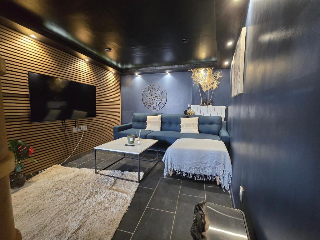un salon avec un canapé bleu et une table dans l'établissement Studio relax maisdon, à Maisdon-sur-Sèvre