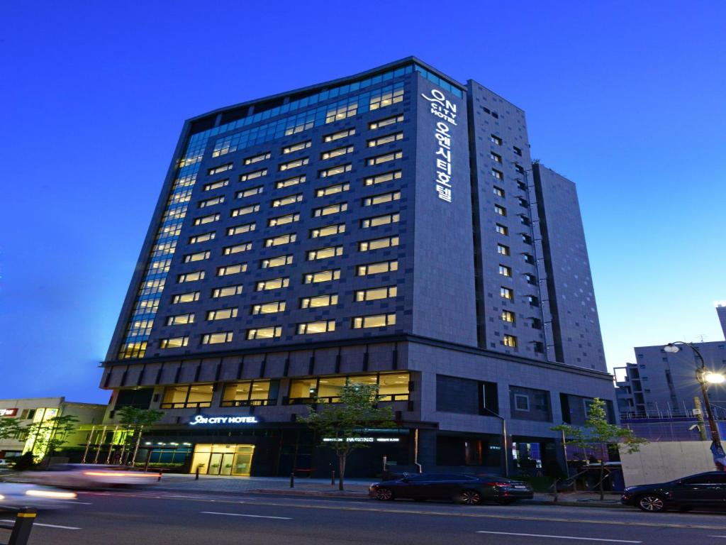 a tall building with a sign on the side of it at ON City Hotel in Cheonan