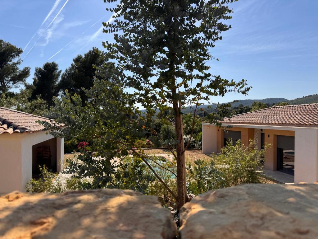 une maison avec un arbre et deux gros rochers dans l'établissement La Villa Douce, entre terre et mer, à Laouque