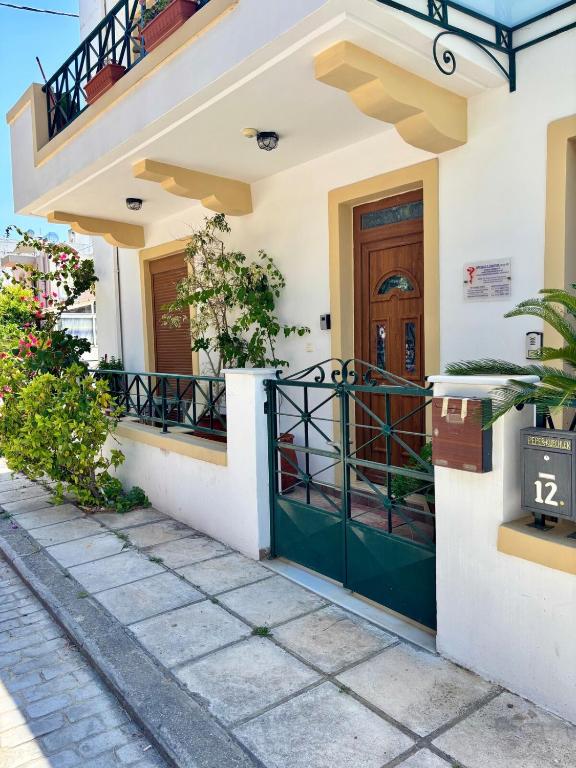 a house with a green door and a balcony at Eleni Seaside Retreat in Kos Town