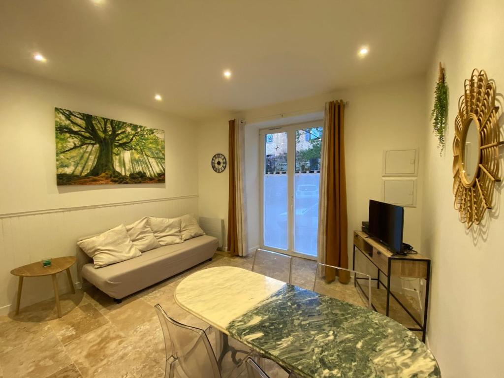 un salon avec un canapé et une table dans l'établissement Appartement au cœur du village, à Saint-Rome-de-Tarn