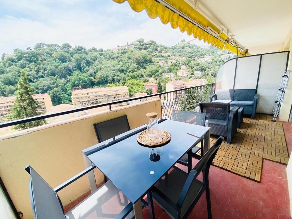 d'un balcon avec une table bleue et des chaises sur le toit. dans l'établissement Le Patricia studio balcon calme vue clim, à Menton