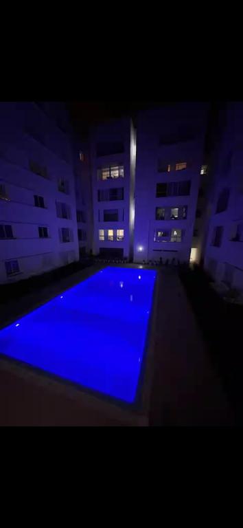 a large blue swimming pool in a building at night at Plage manesmann in Mohammedia